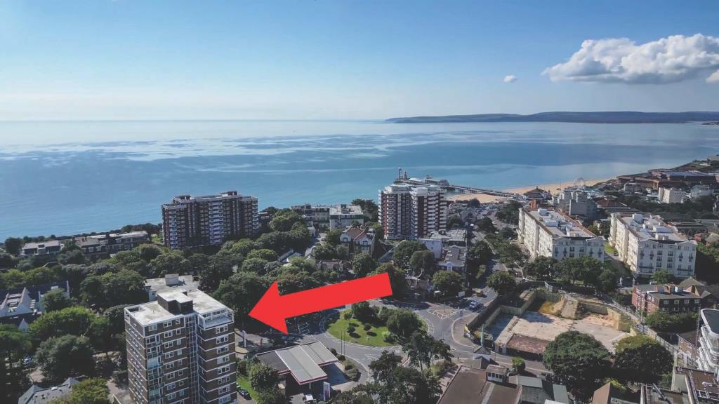 Lot: 19 - FLAT FOR INVESTMENT IN PRIME TOWN CENTRE LOCATION - Drone photo of the building with the sea in the background
